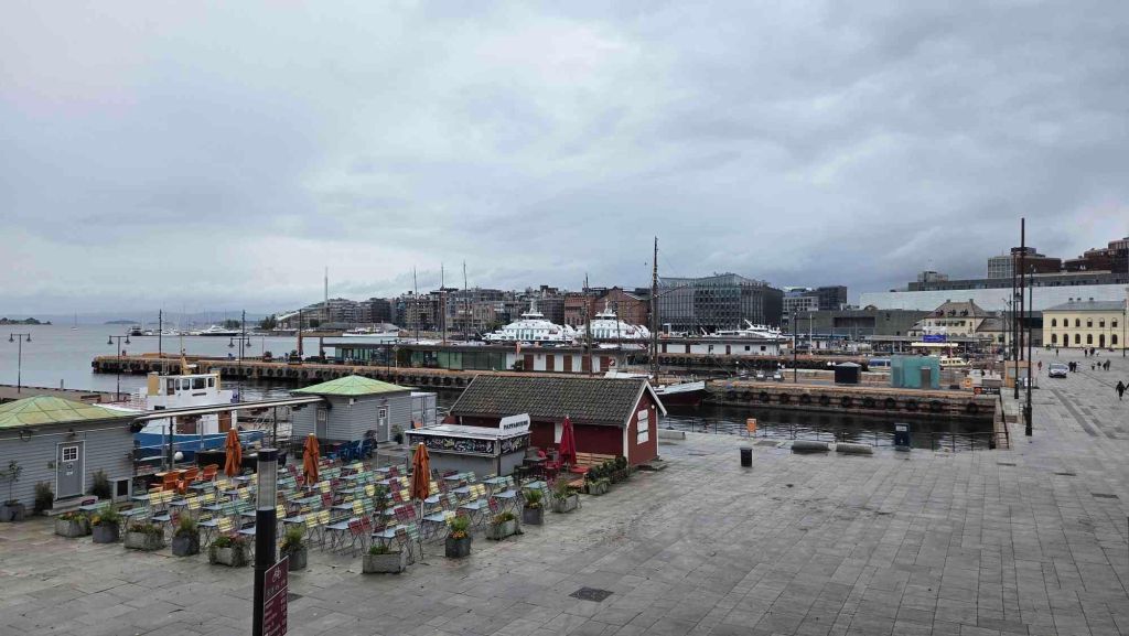 Promenade Aker Brygge Oslo mit Cafés und Blick auf den Hafen