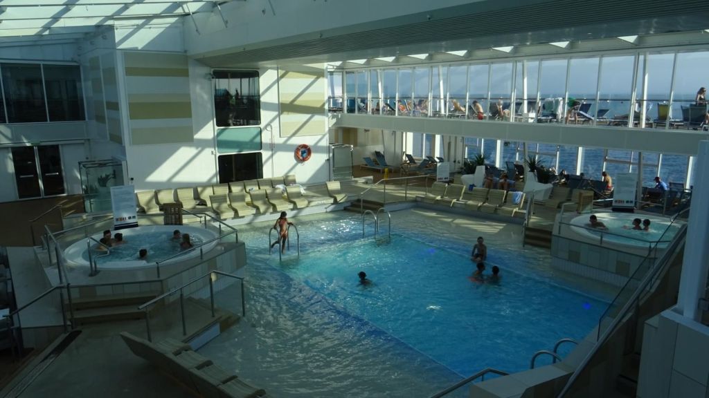Überdachter Innenpool auf der Mein Schiff 3 mit Whirlpools und Ruhebereich
